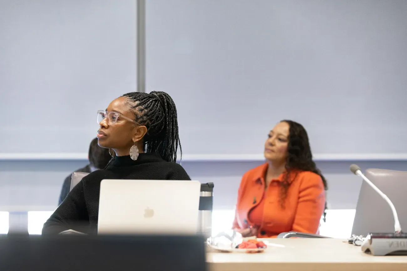 Students sitting at a desk and listening to a lecture.